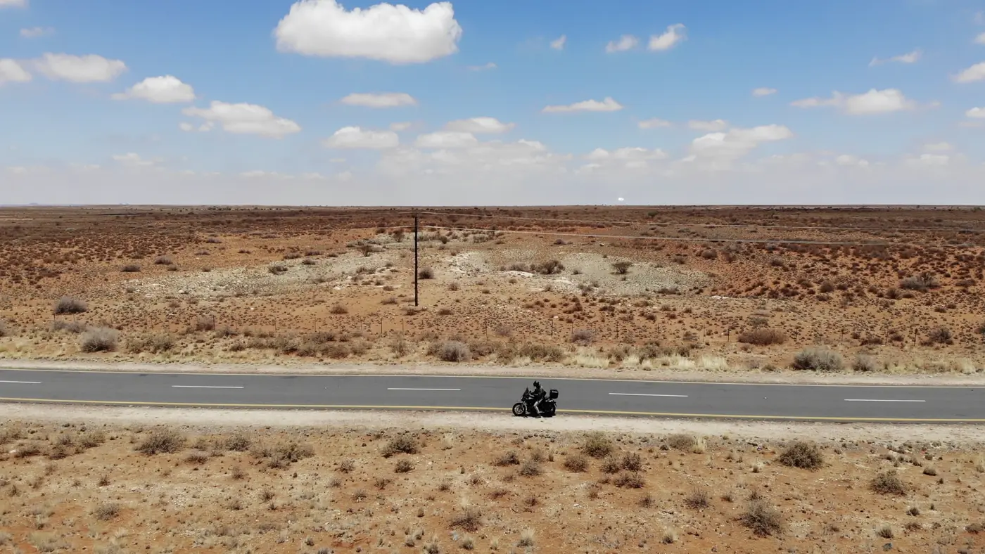 An electric motorbike on an empty road through the Namibian semi-desert